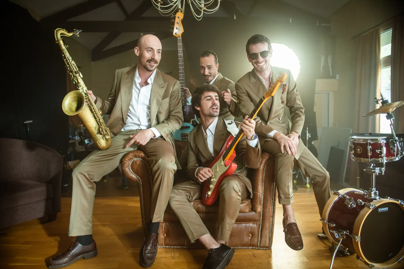 The Brotherockers seated with their instruments in a wood-panelled salon