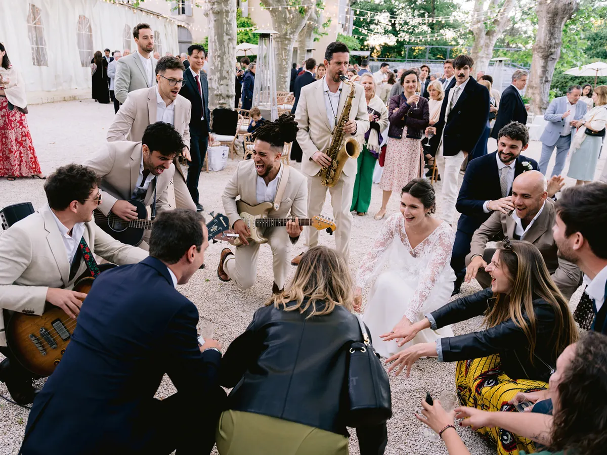 The band among guests in a garden, everyone singing