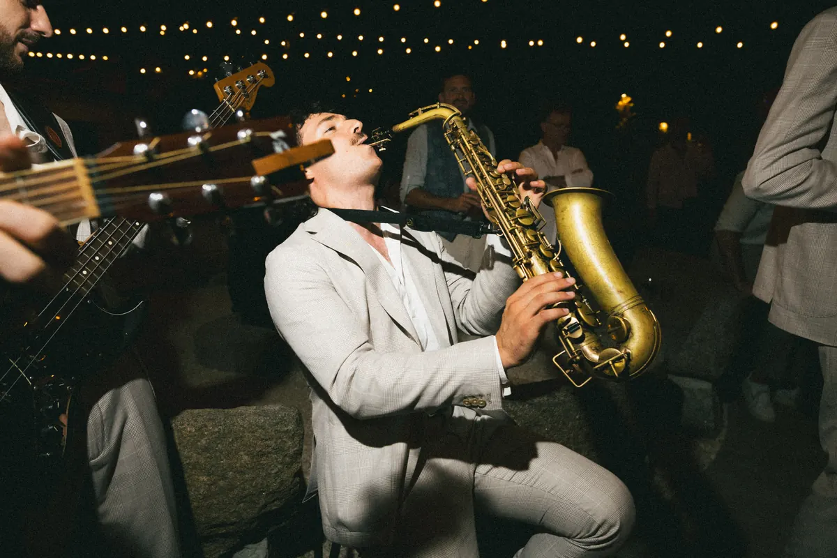 Saxophonist under string lights