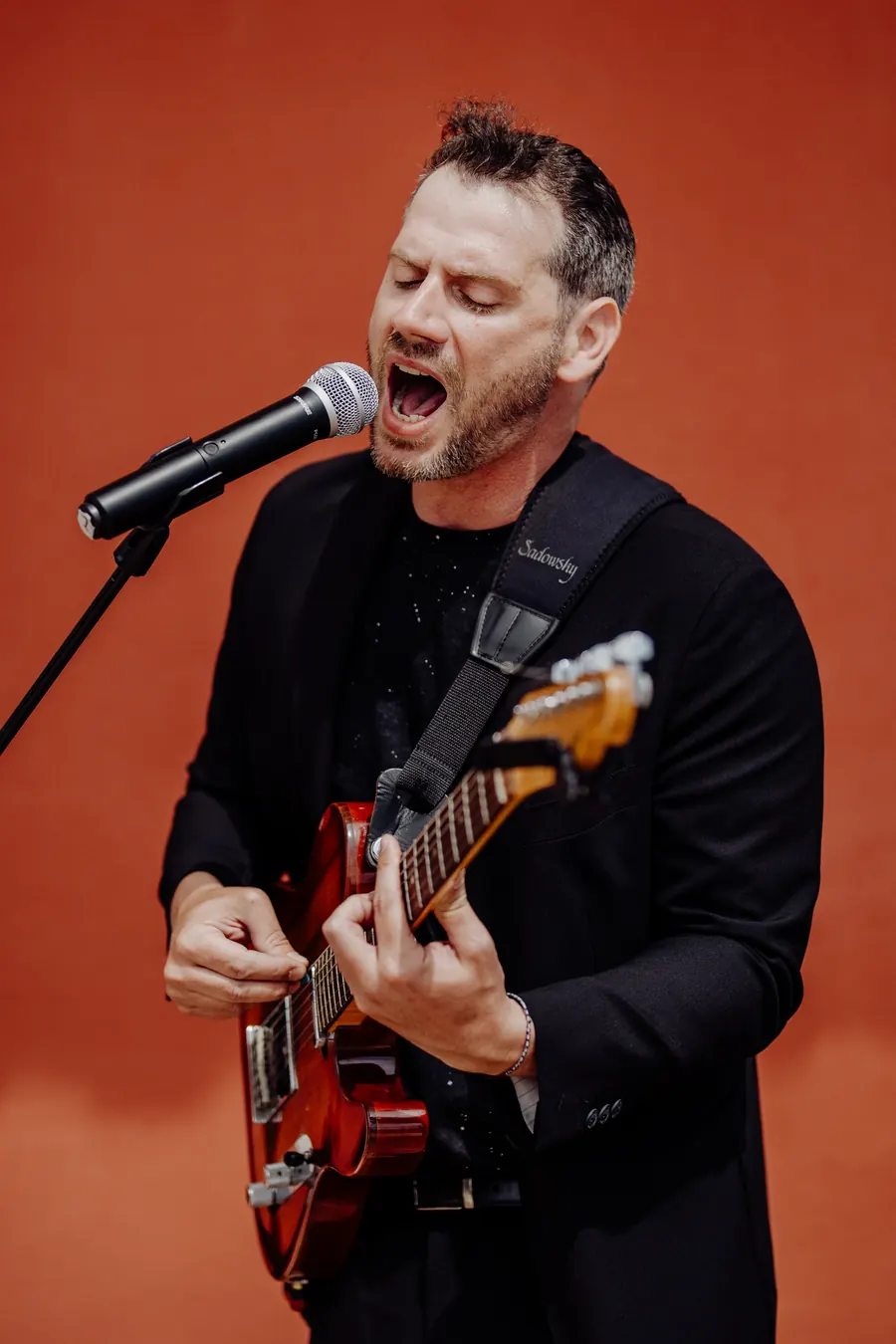 A singer at the microphone in an amplified set-up