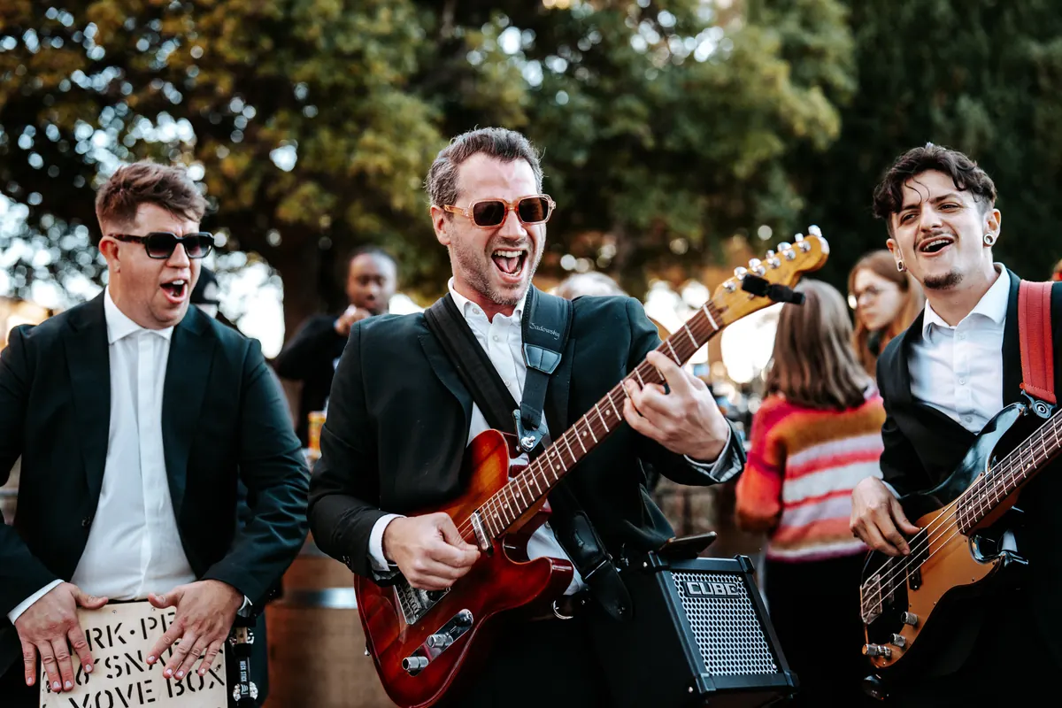 The trio with electric guitars at a garden party