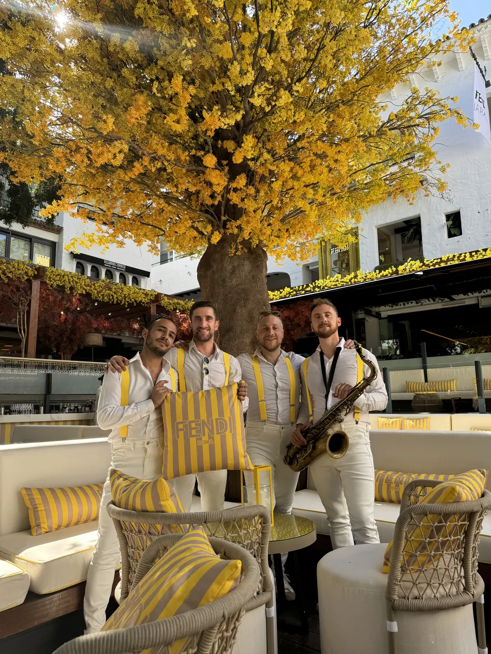 The band under a golden tree at a launch