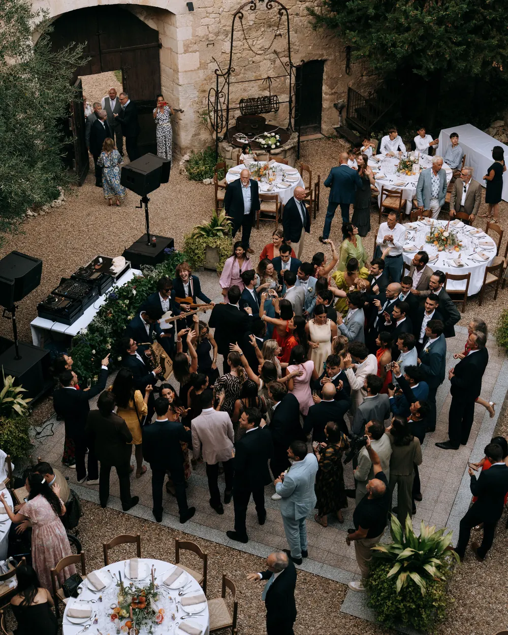 Aerial view of the band among dinner tables in a stone courtyard