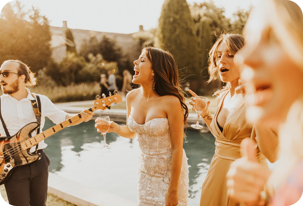The bride singing along by the pool with the guitarist