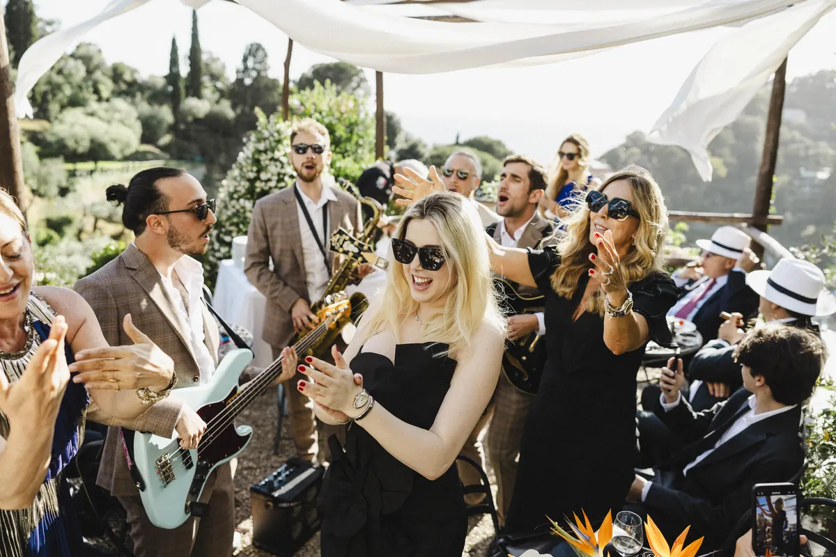Guests clapping along under a white canopy