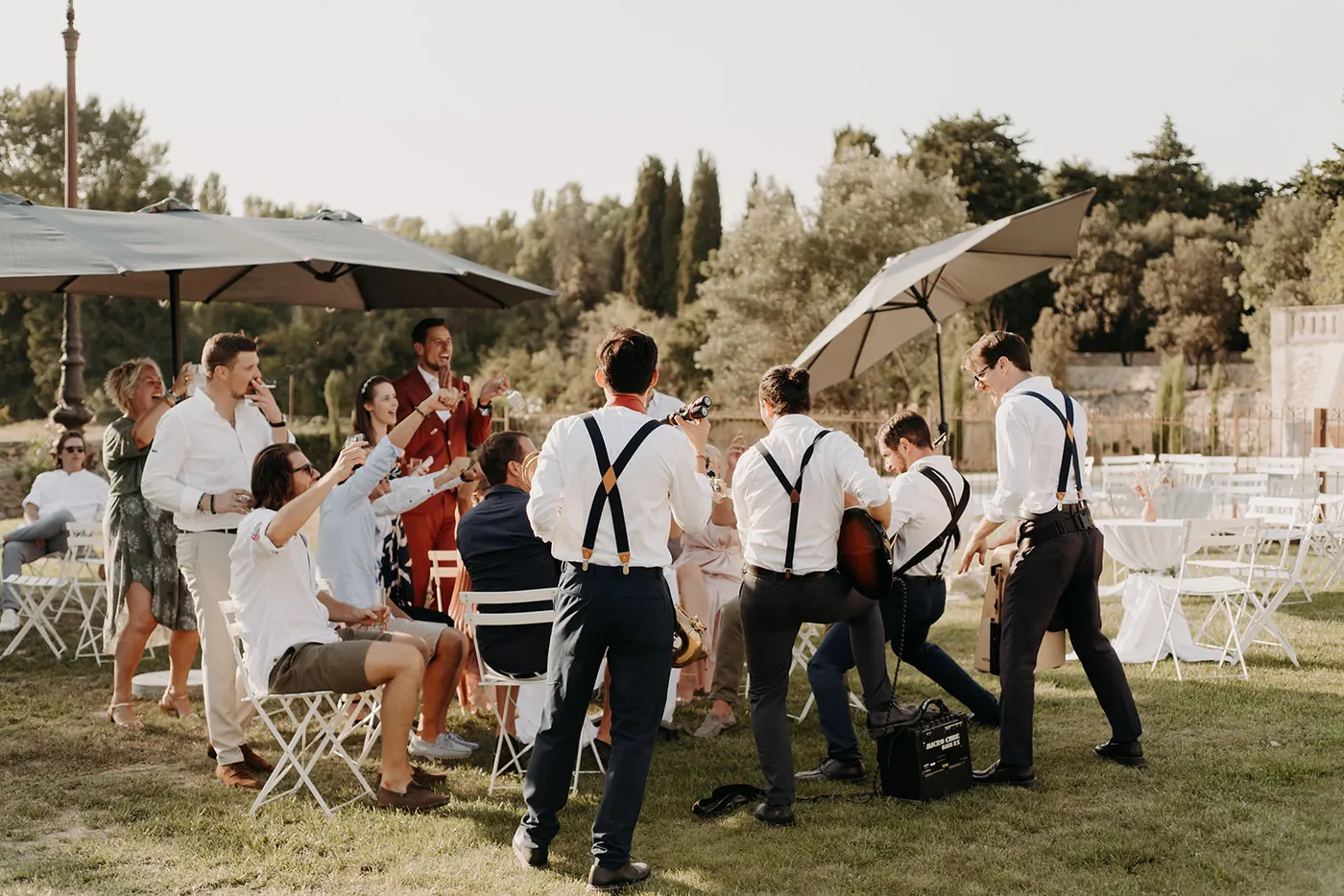 The band walking between the tables of a garden reception